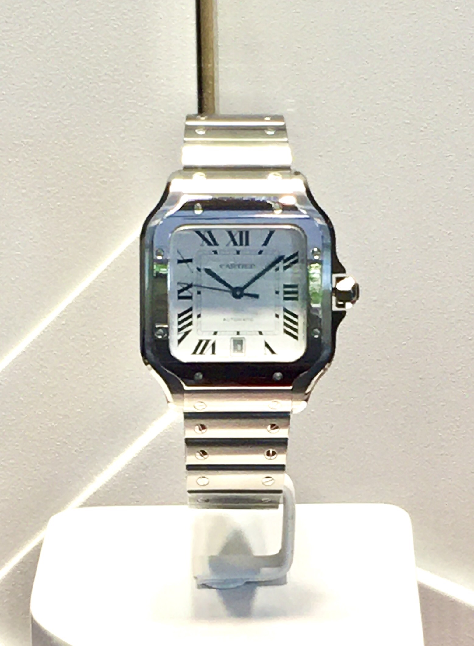 Montre Cartier Santos en acier, bracelet intégré à maillons carrés, cadran blanc avec chiffres romains et couronne saphir