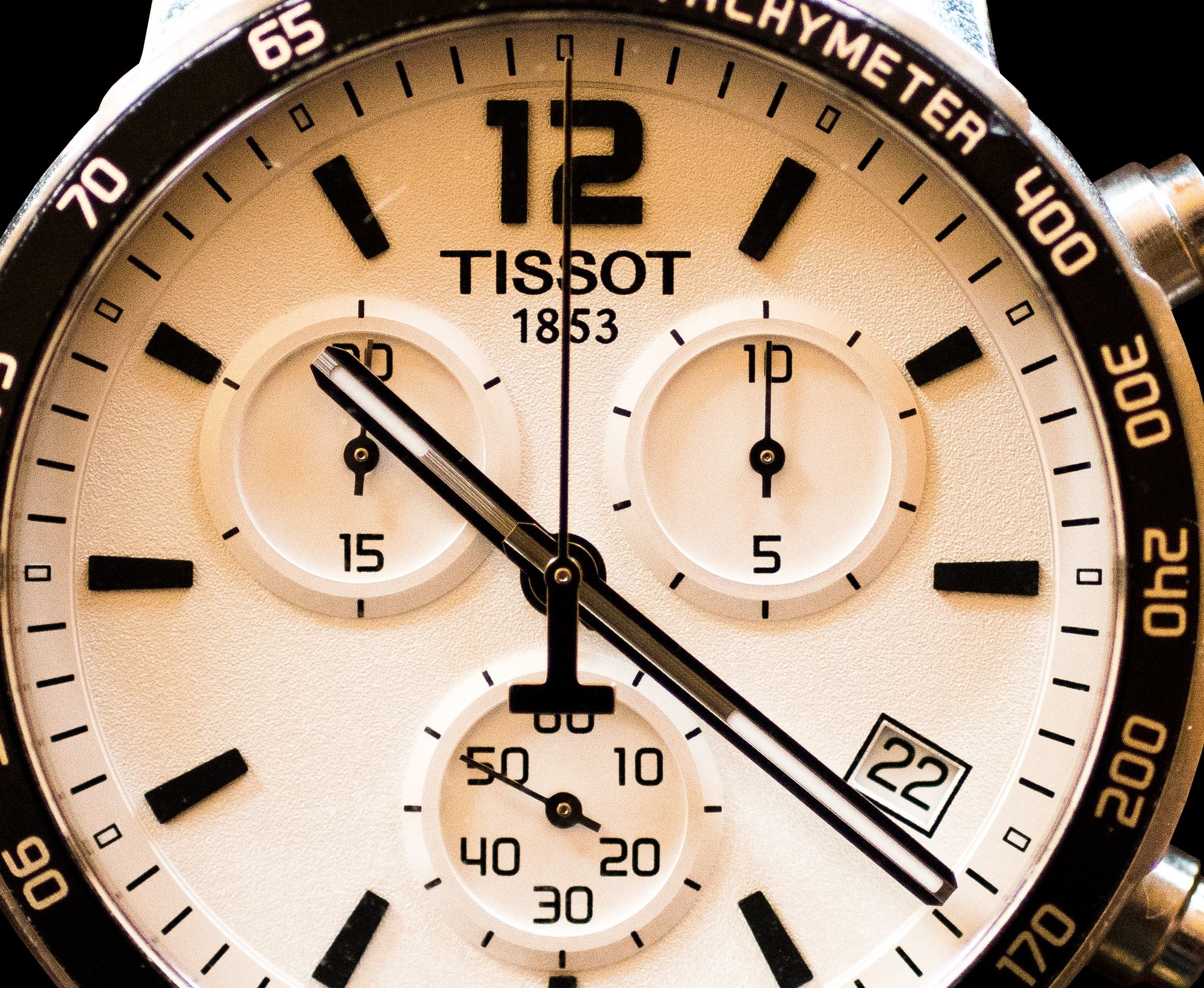 Détail des aiguilles et sous-cadrans d'un chronographe Tissot sur fond noir